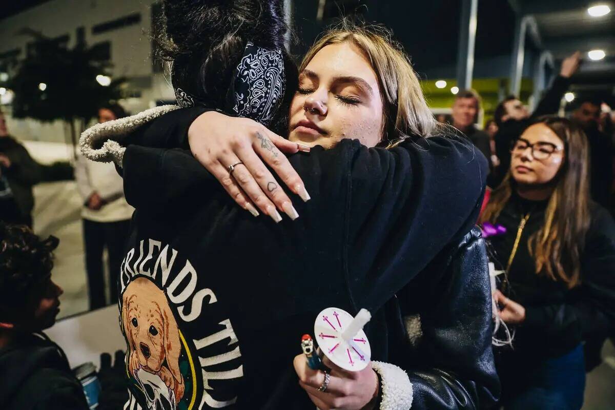 Leighonna Post, de frente, abraza a un doliente durante una vigilia por su madre, Rebecca Post, ...