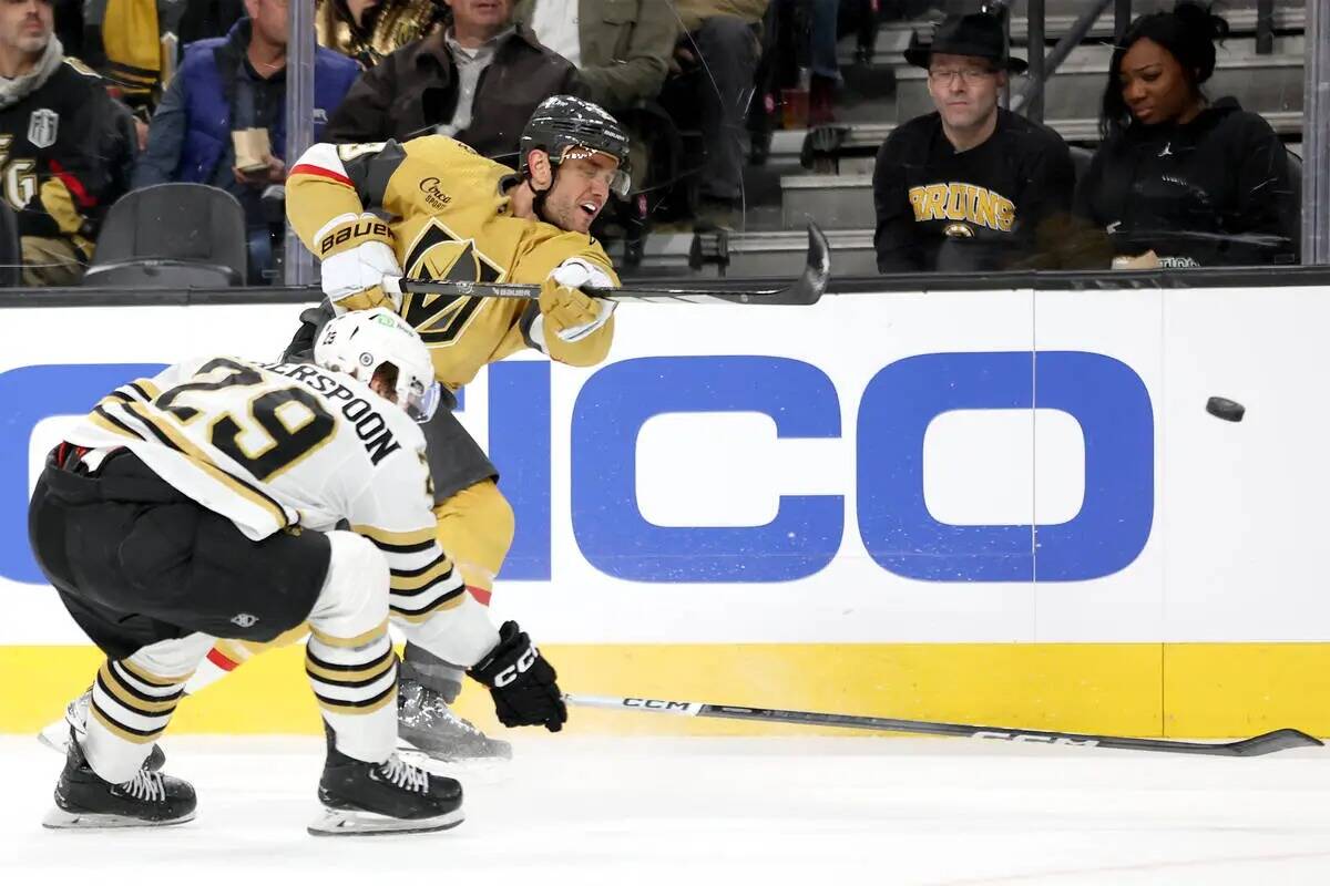 El defensa de los Golden Knights Alec Martinez (23) dispara mientras el defensa de los Bruins P ...