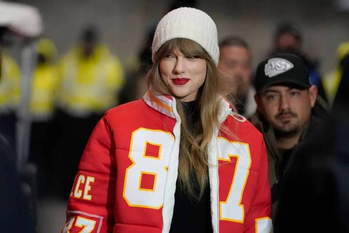 Taylor Swift lleva una chaqueta del ala cerrada de los Kansas City Chiefs Travis Kelce mientras ...