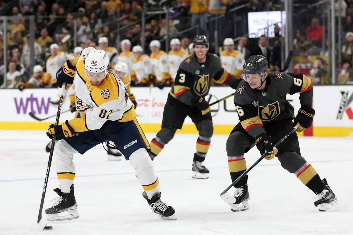 El centro de los Nashville Predators Tommy Novak (82) patina con el puck contra el defensa de l ...