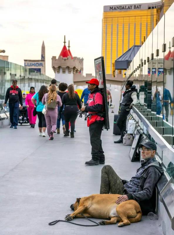 Los peatones caminan mientras mendigos, anunciantes y artistas ocupan lugares a lo largo del pu ...