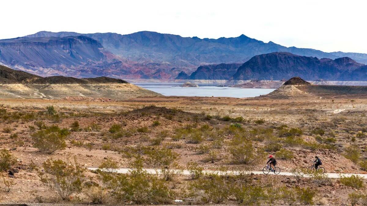 Un ciclista recorre el sendero River Mountains Loop Trail con el aumento de la costa en la dist ...