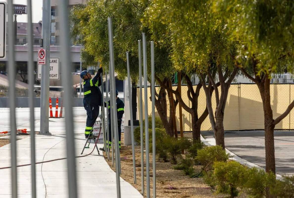 Una cuadrilla coloca postes para la nueva fila de vallas exteriores mientras continúan los pre ...