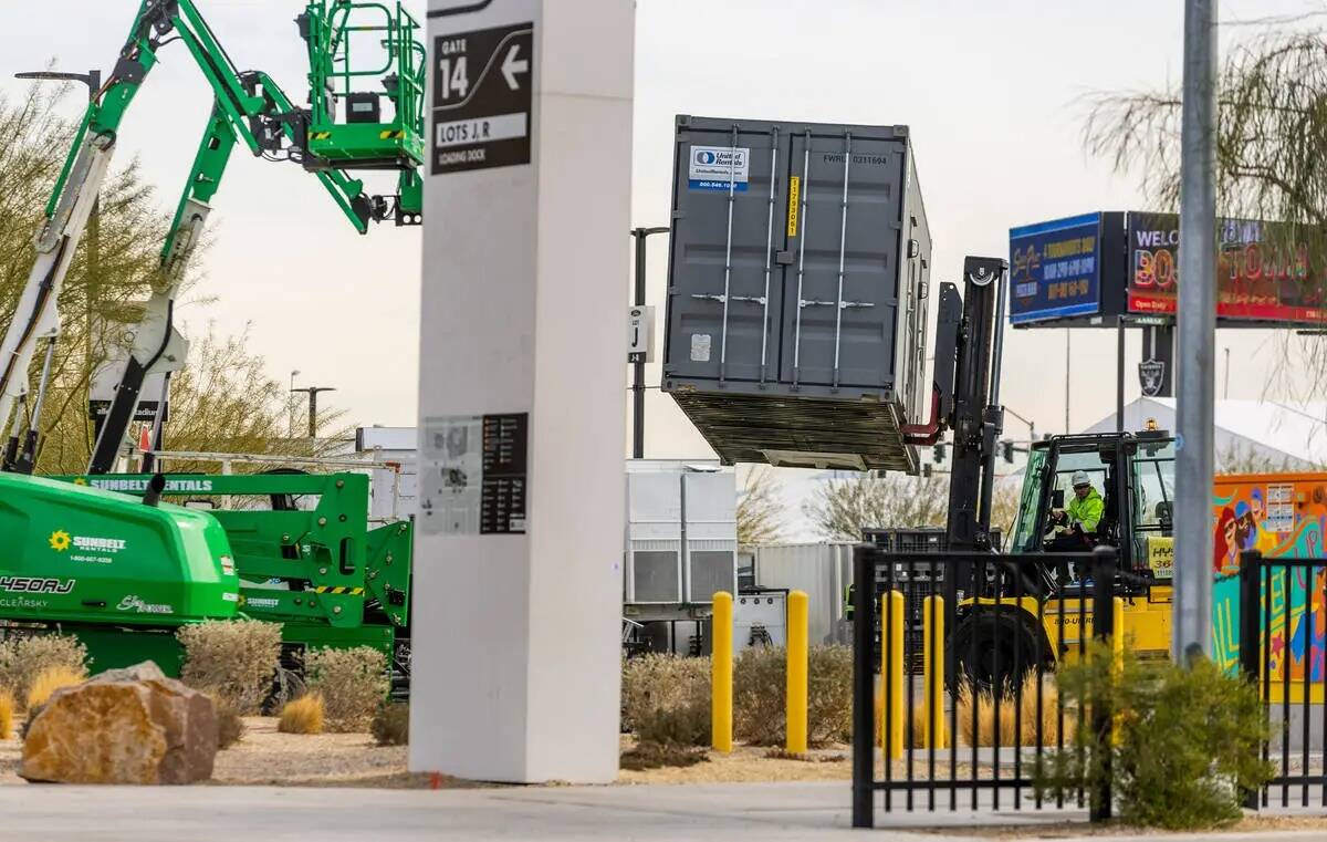 Contenedores son trasladados a su lugar en un estacionamiento mientras continúan los preparati ...