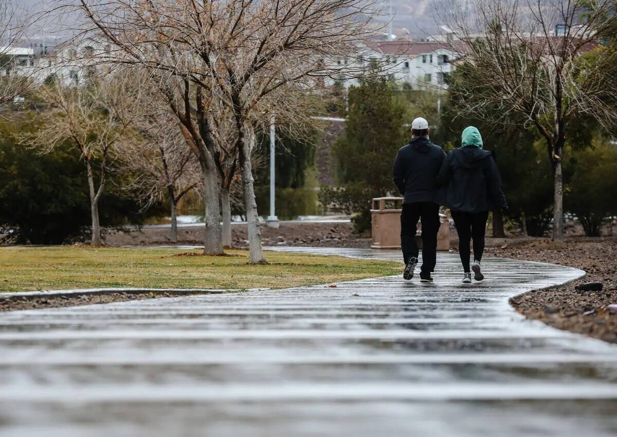 Una pareja camina por Cornerstone Park tras la lluvia en Henderson, el lunes 22 de enero de 202 ...