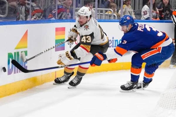 Adam Pelech (3) de los New York Islanders y Paul Cotter (43) de los Vegas Golden Knights buscan ...