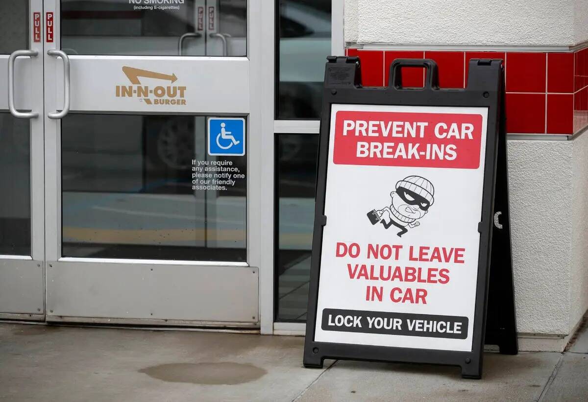 Un letrero advierte a los clientes sobre los robos de auto en el restaurante In-N-Out cerca de ...