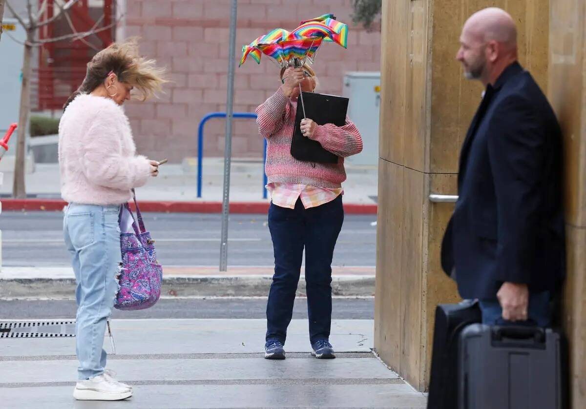 La gente lidia con el viento y la lluvia en el centro de Las Vegas el miércoles 31 de enero de ...