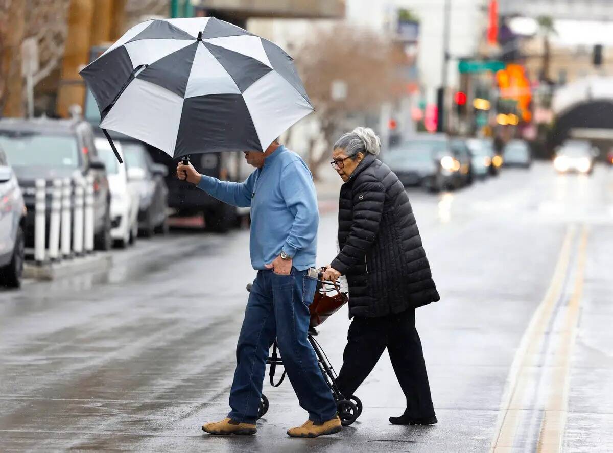 Peatones cruzan Third Street durante una mañana lluviosa, el jueves 1° de febrero de 2024, en ...