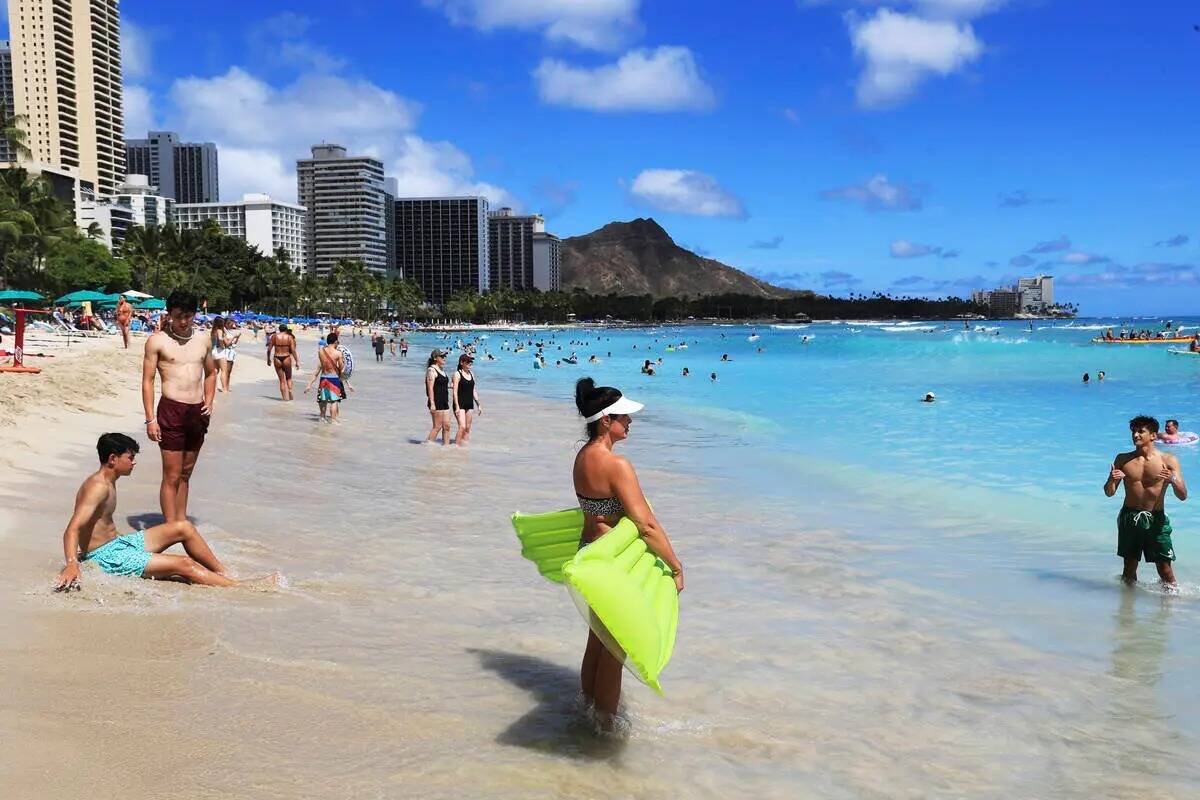 Vacacionistas se lanzan a las olas en Waikiki Beach en Honolulu, donde ocho representantes del ...