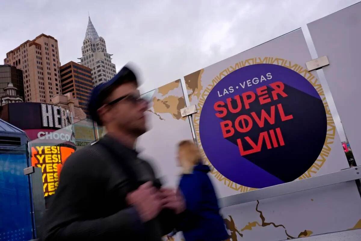 Peatones pasan junto a la señalización del Super Bowl 58 de la NFL, el martes 6 de febrero de ...
