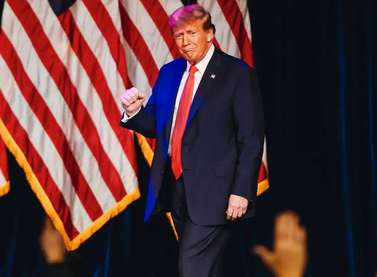 El expresidente Donald Trump levanta su puño mientras entra a hablar en una fiesta de observac ...