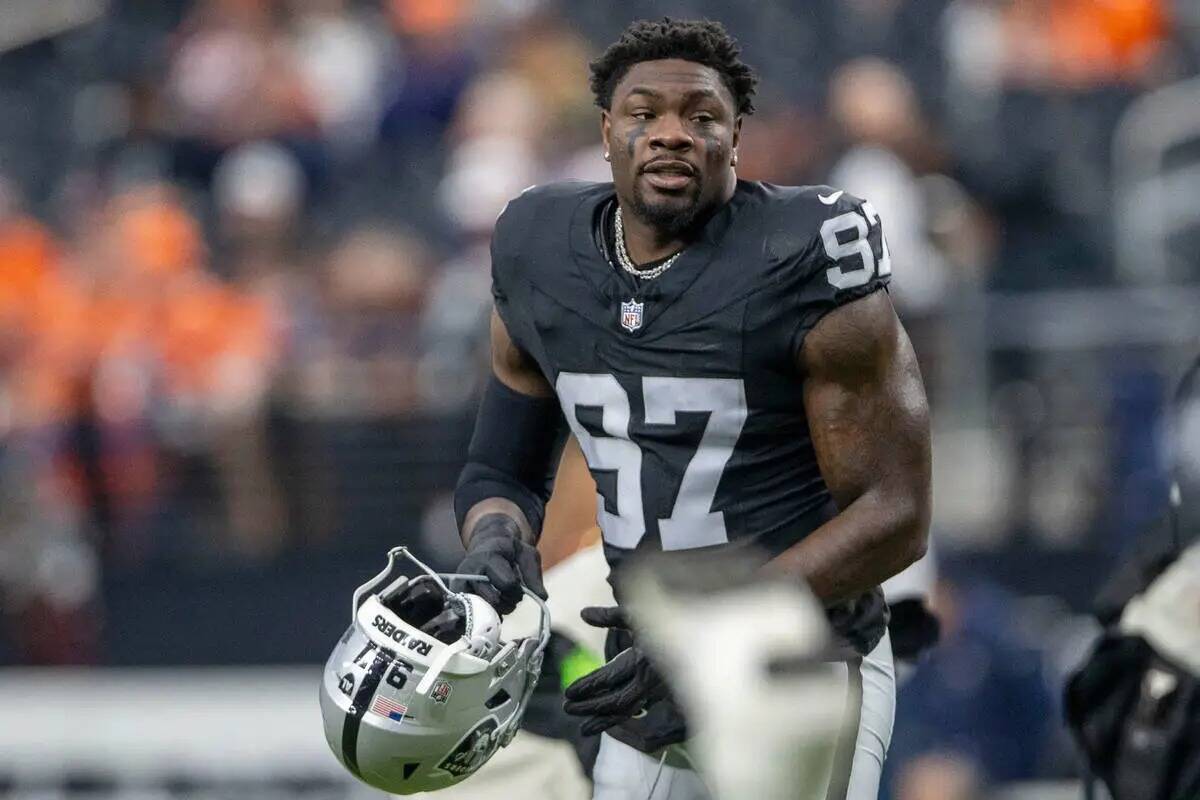 El defensive end de los Raiders Janarius Robinson (97) estira antes de un partido de la NFL con ...