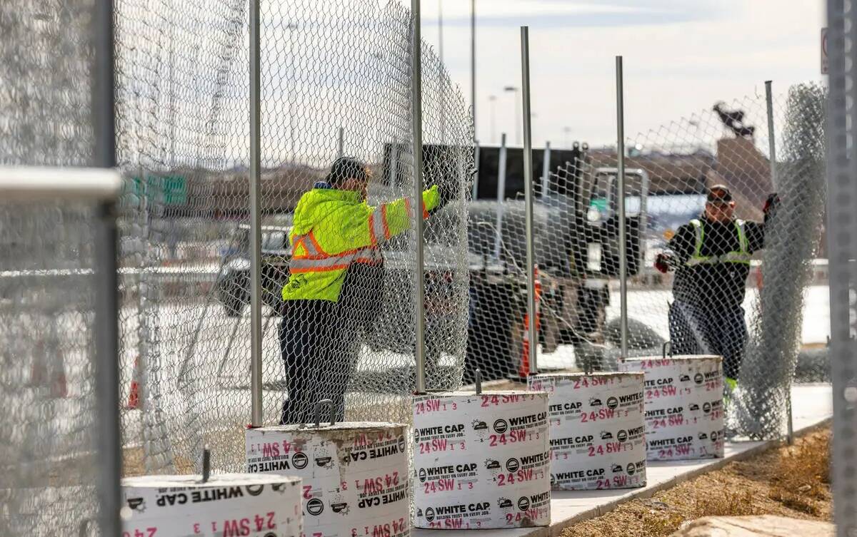 Una cuadrilla coloca una nueva fila de vallas exteriores mientras continúan los preparativos p ...