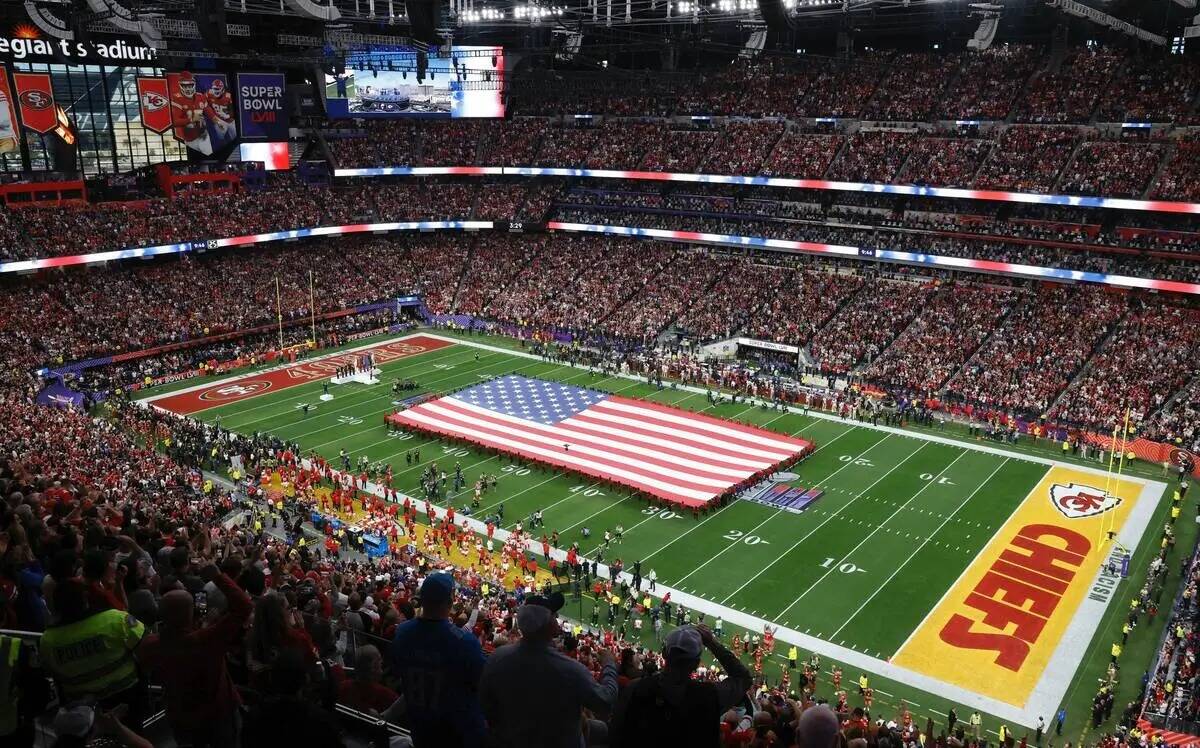 Una bandera de Estados Unidos se extiende sobre el campo antes del Super Bowl 58, el domingo 11 ...