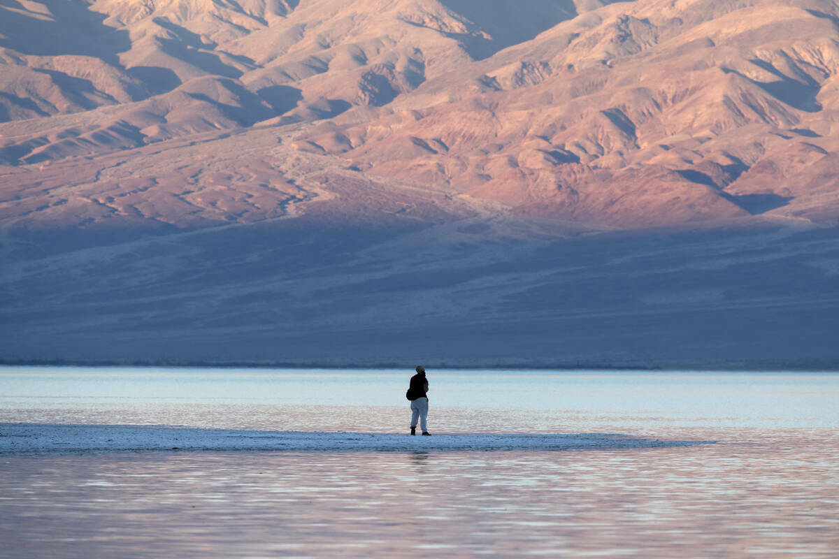 Un visitante observa un lago poco común en Badwater Basin, en el Death Valley National Park en ...