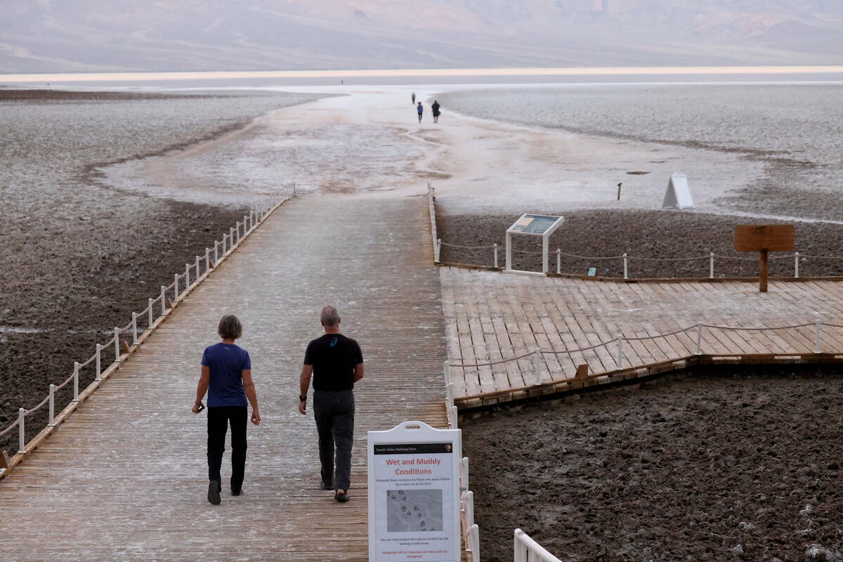 Visitantes observan un lago poco común en Badwater Basin, en el Death Valley National Park en ...