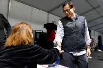 El secretario de Estado de Nevada, Cisco Aguilar, estrecha la mano de la trabajadora electoral ...