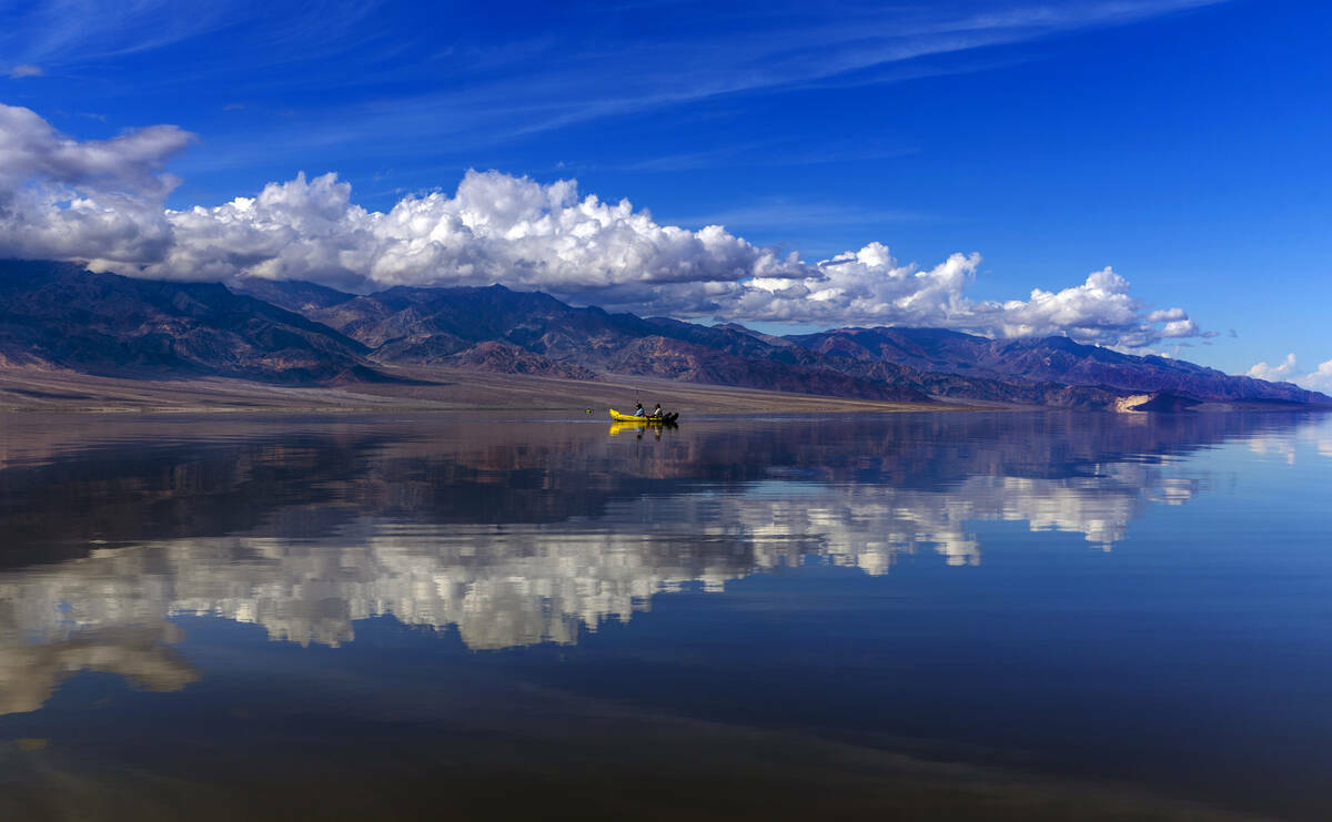 Personas reman en kayaks en el lago temporal Manly en Badwater Basin, en el Death Valley Nation ...