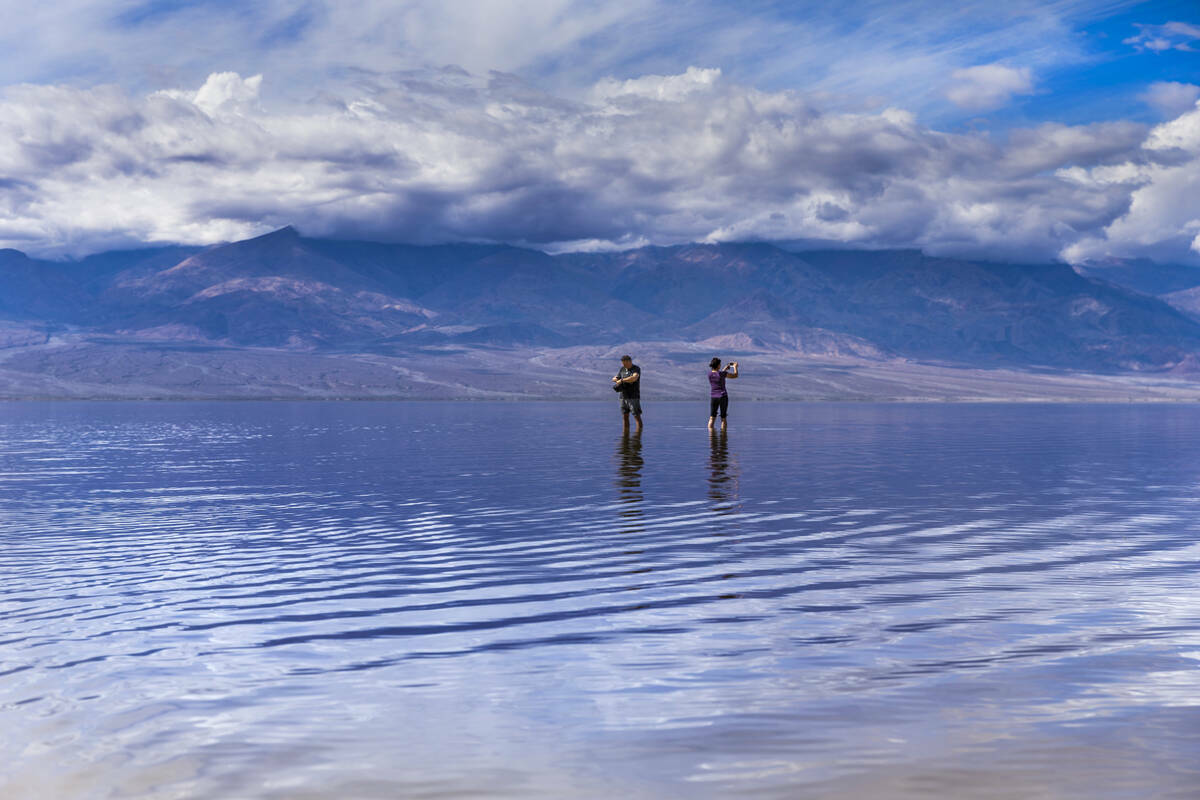 Visitantes pasean y se toman fotos en el lago temporal Manly en Badwater Basin, en el Death Val ...