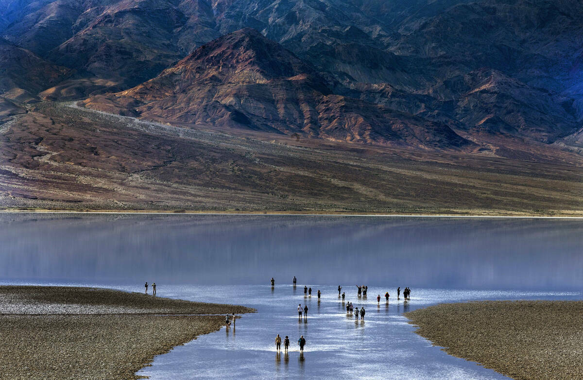 Personas entran y salen del agua en el lago temporal Manly en Badwater Basin, en el Death Valle ...