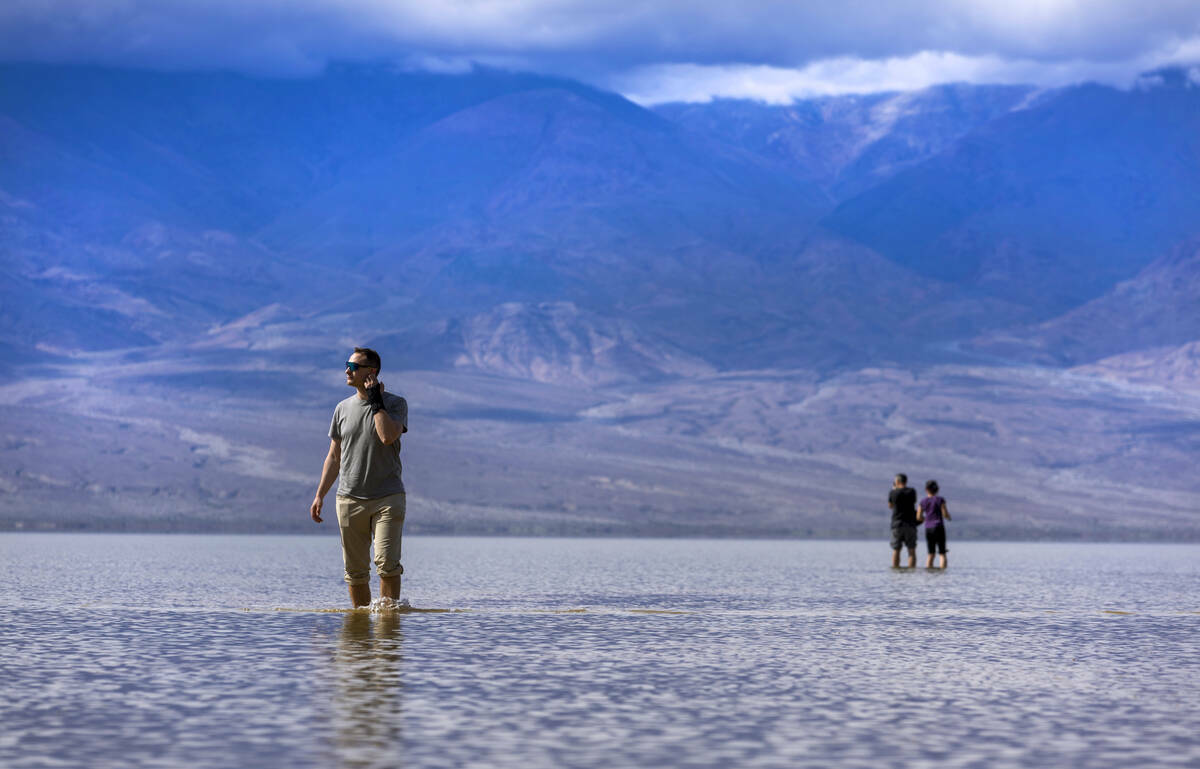 Visitantes pasean por el lago temporal Manly en Badwater Basin, en el Death Valley National Par ...
