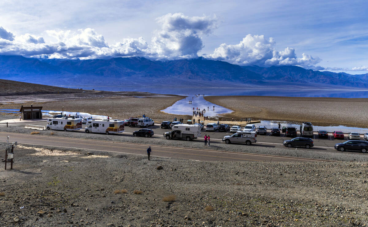 Personas entran y salen del agua en el lago temporal Manly en Badwater Basin, en el Death Valle ...