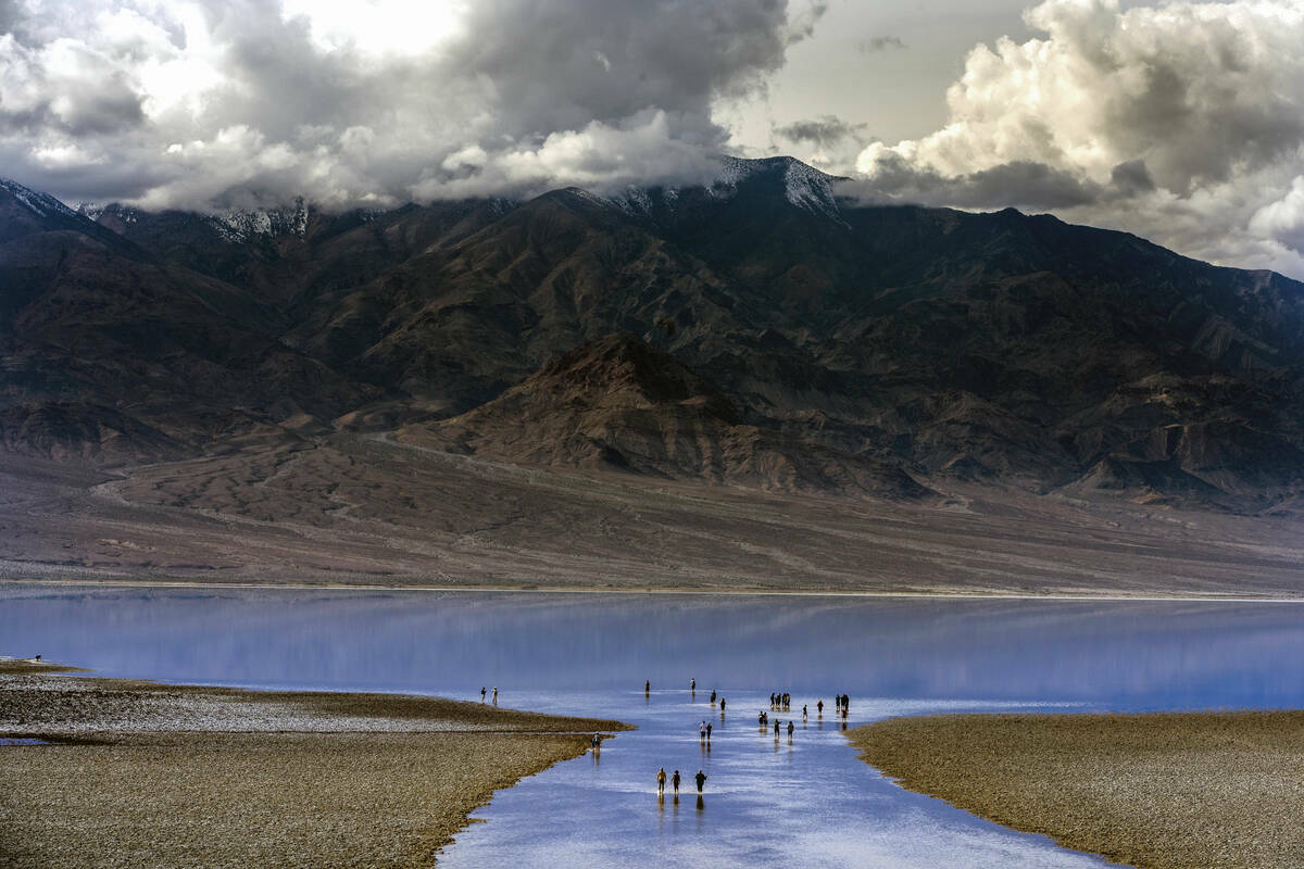 Personas entran y salen del agua en el lago temporal Manly en Badwater Basin, en el Death Valle ...