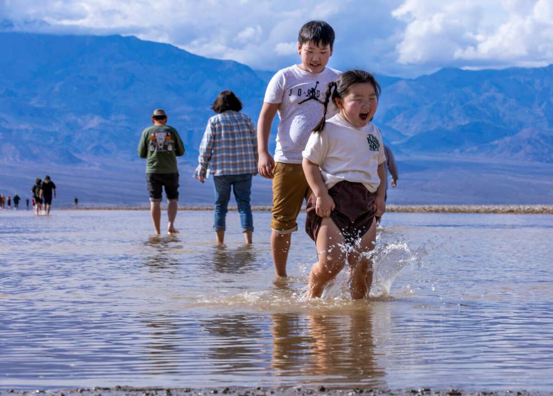 Personas entran y salen del agua en el lago temporal Manly en Badwater Basin, en el Death Valle ...