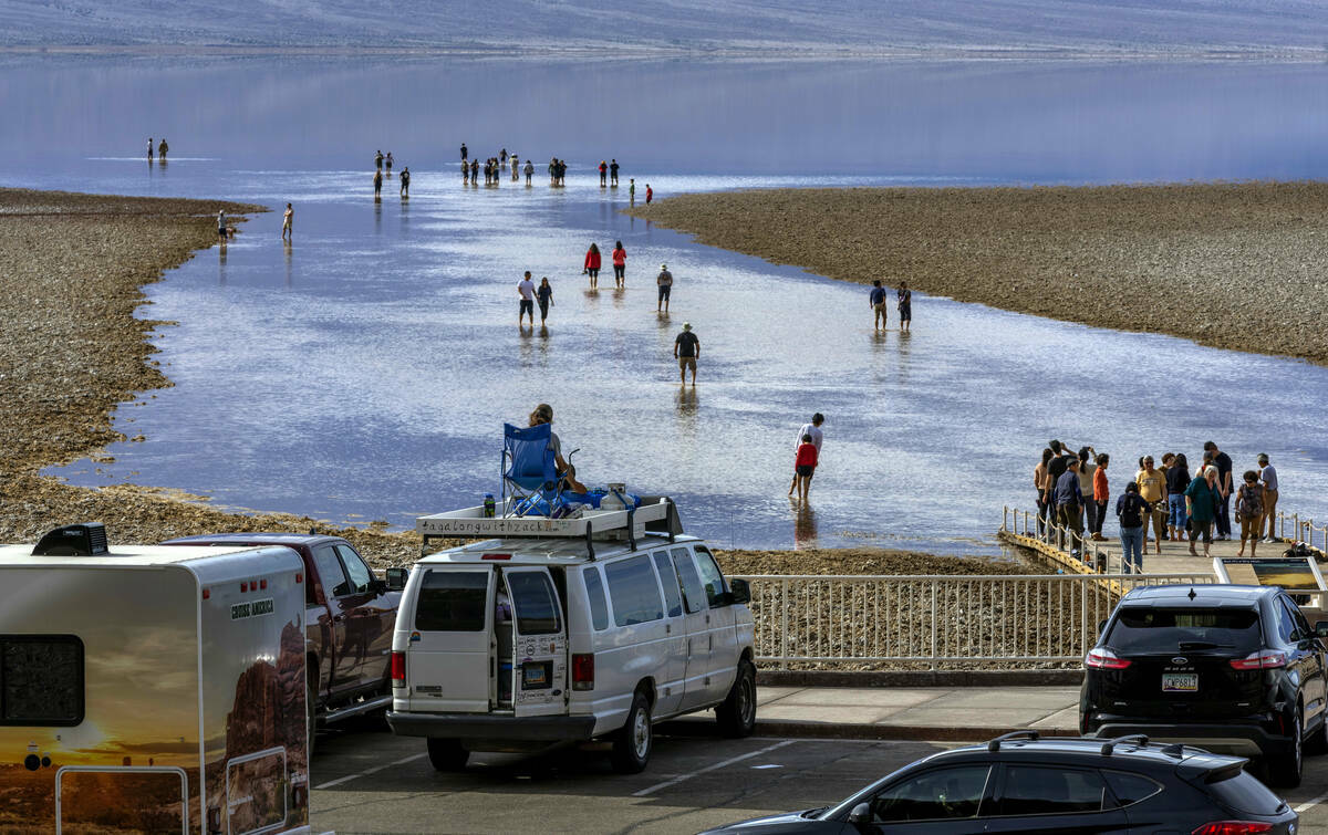 Personas entran y salen del agua en el lago temporal Manly en Badwater Basin, en el Death Valle ...