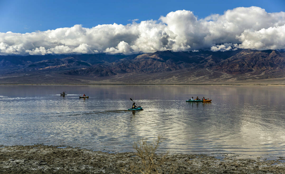 Personas reman en kayaks en el lago temporal Manly en Badwater Basin, en el Death Valley Nation ...