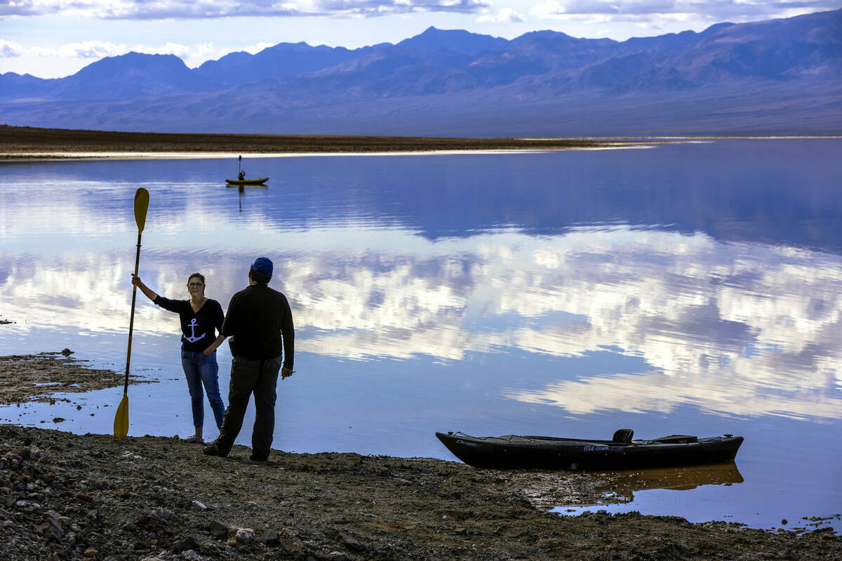 Personas reman en kayaks en el lago temporal Manly en Badwater Basin, en el Death Valley Nation ...