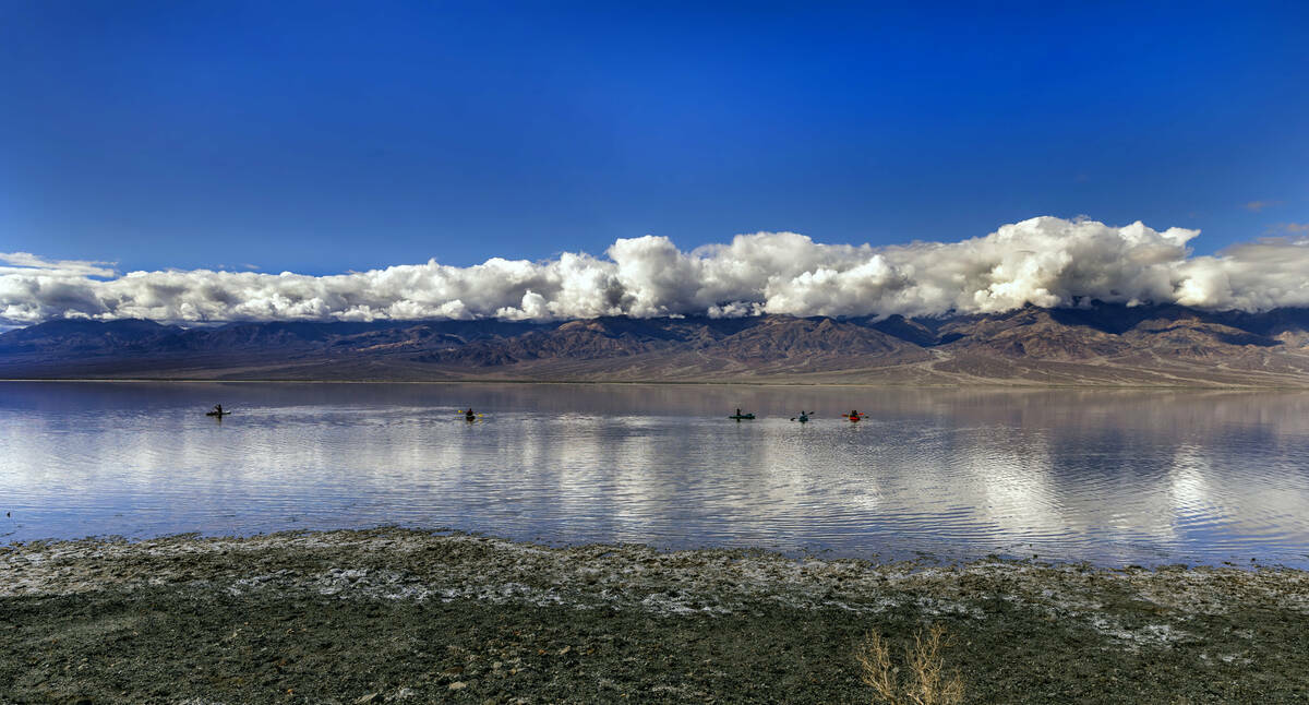 Personas reman en kayaks en el lago temporal Manly en Badwater Basin, en el Death Valley Nation ...