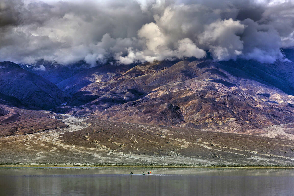 Personas reman en kayaks en el lago temporal Manly en Badwater Basin, en el Death Valley Nation ...