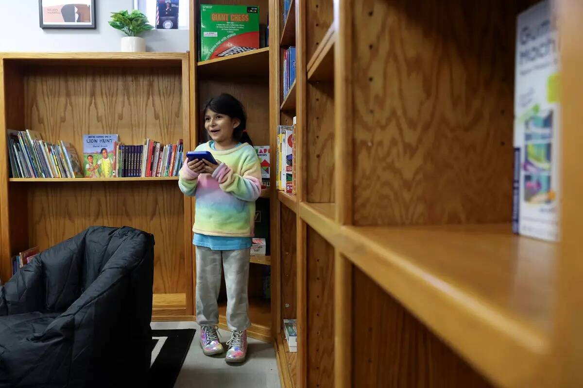Maya Dzul, de 6 años, hace una selección en la biblioteca durante un evento de apertura en el ...