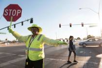 La guardia de cruce Patricia Bass ayuda a un niño a cruzar Lake Mead Boulevard en Tonopah Driv ...