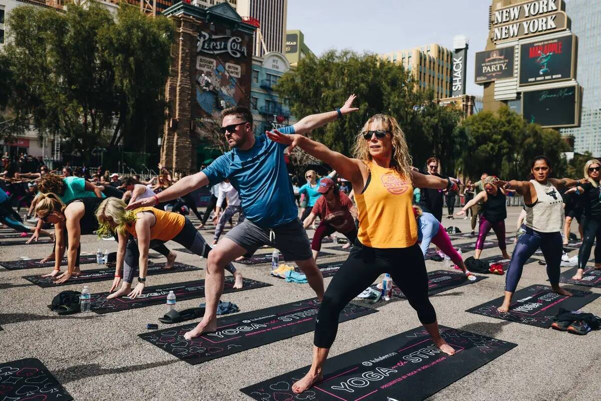 La gente se reúne en el Strip para hacer yoga mientras está cerrado por la Rock 'n' Roll Runn ...
