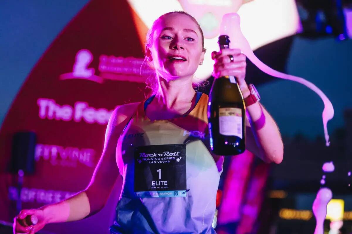 Alice Wright rocía champán tras quedar primera en el medio maratón femenina durante la Rock ...