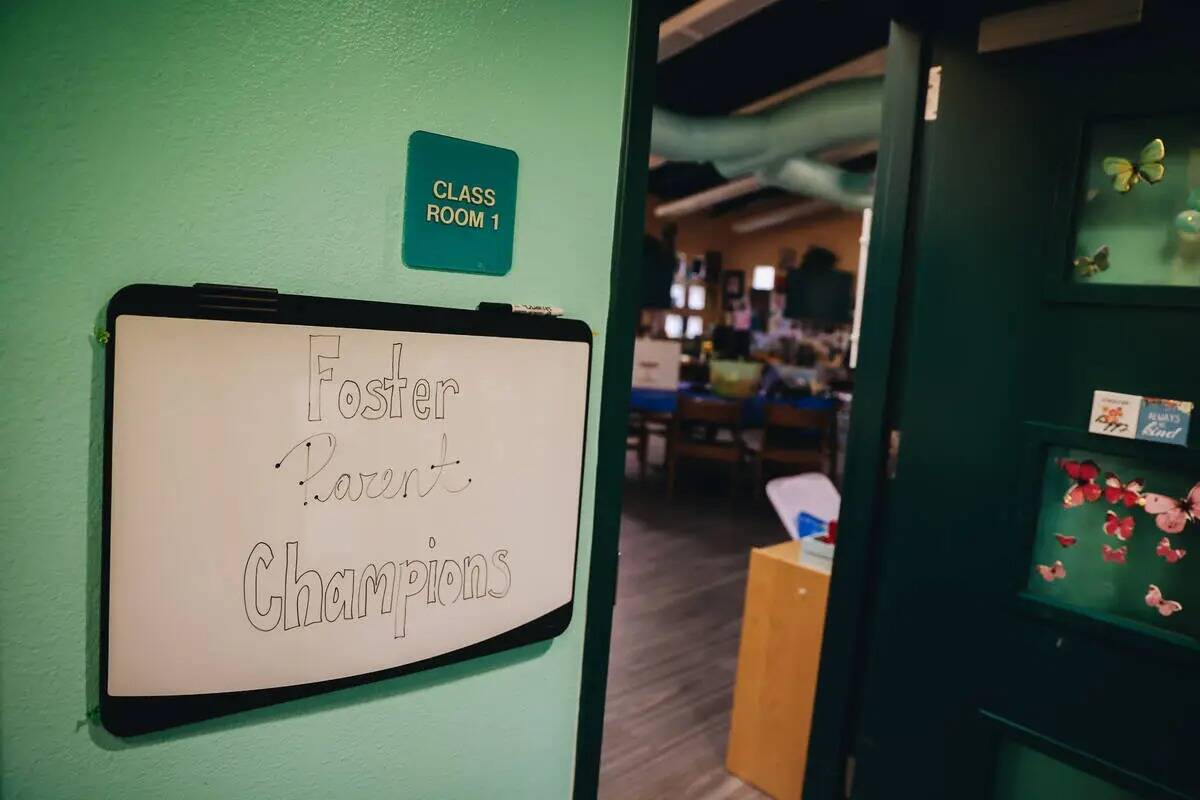 Un letrero de "Foster Parent Champions" se ve en la entrada de una sala administrativa en el ca ...
