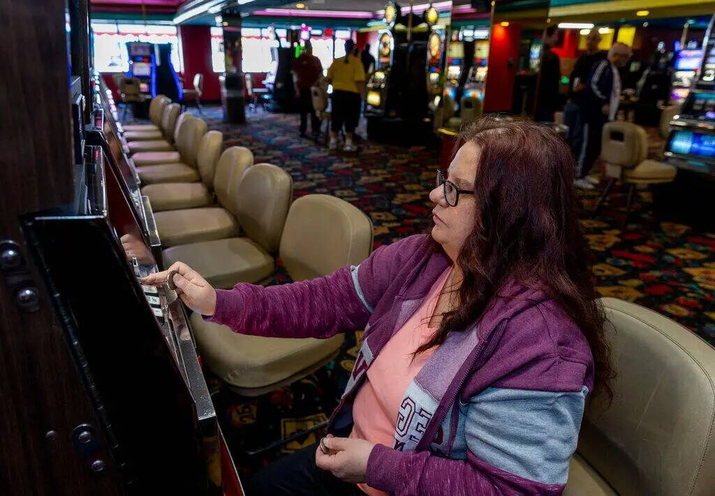 Wendy Womack, de Texas, introduce monedas de un dólar en una máquina de Slots A Fun, la renov ...