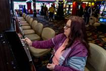 Wendy Womack, de Texas, introduce monedas de un dólar en una máquina de Slots A Fun, la renov ...