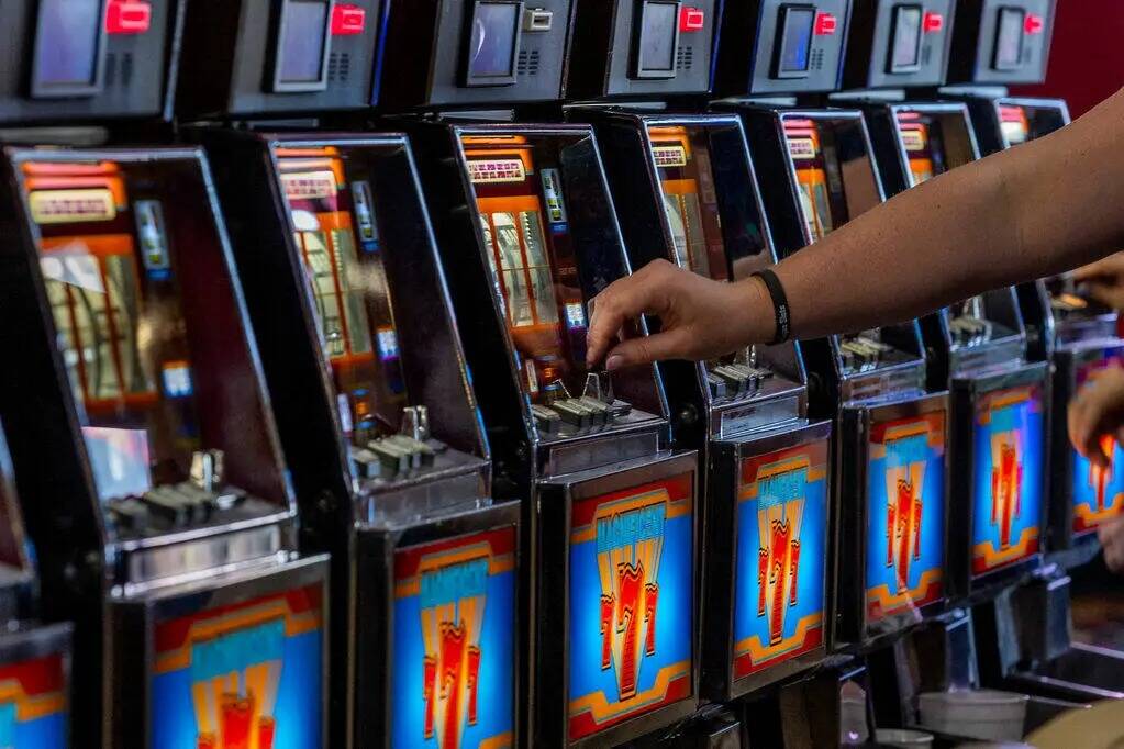 Un jugador introduce una moneda en una máquina en Slots A Fun, la renovada zona de tragamoneda ...