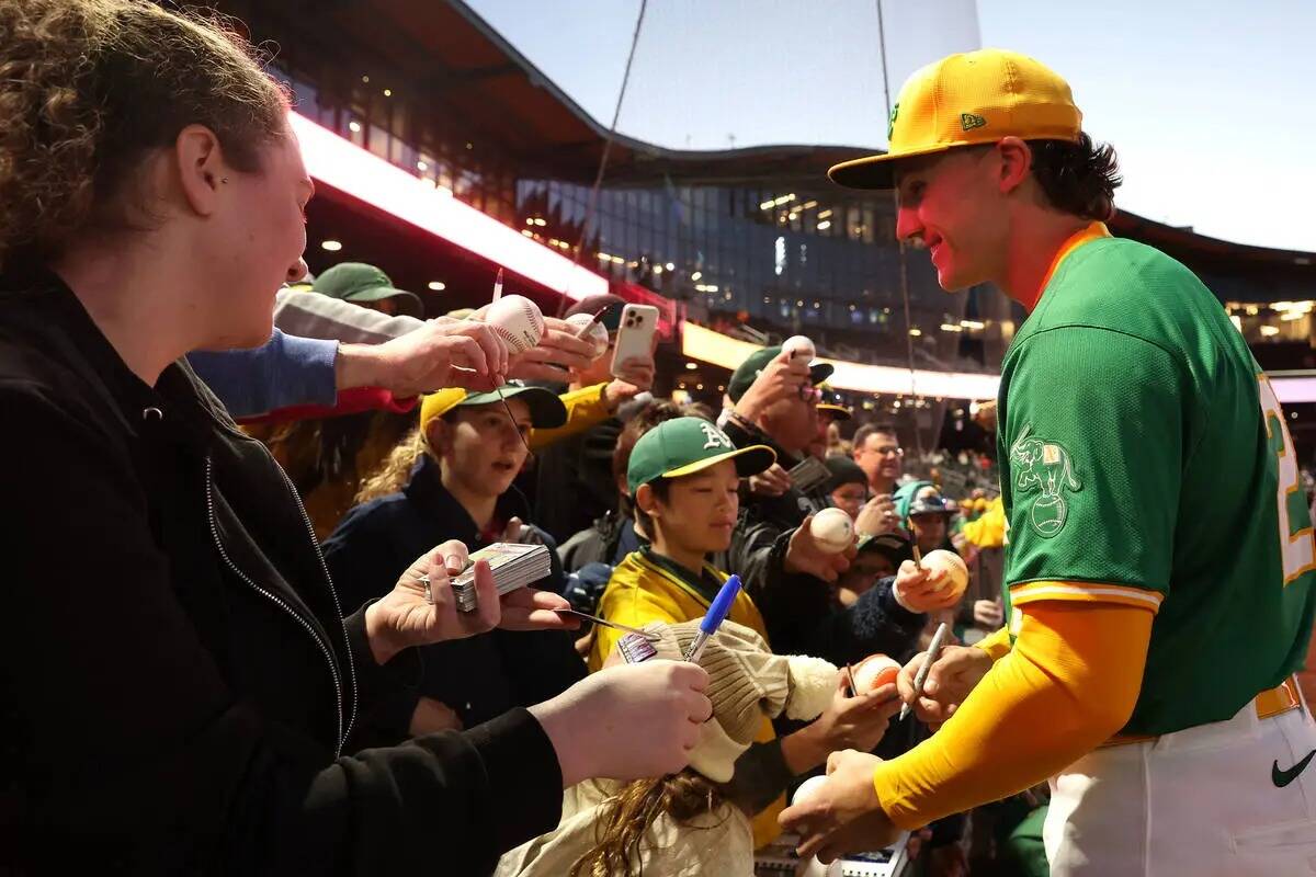 El segunda base de los Oakland Athletics, Zack Gelof (20), firma autógrafos para los fans ante ...