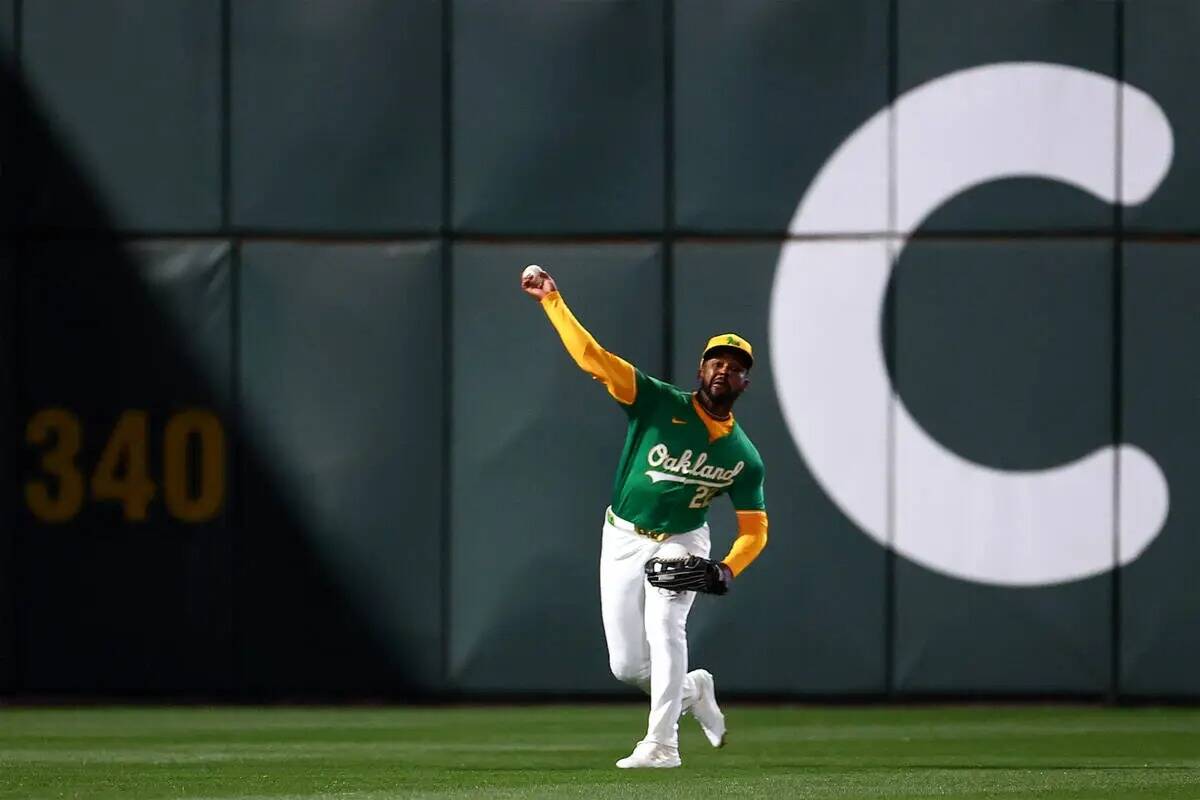 El jardinero de los Oakland Athletics Miguel Andujar (22) lanza al campo durante un partido de ...