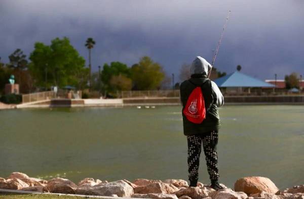 Un pescador espera un bocado como cielos tormentosos se ciernen sobre Lorenzi Park el jueves, 1 ...