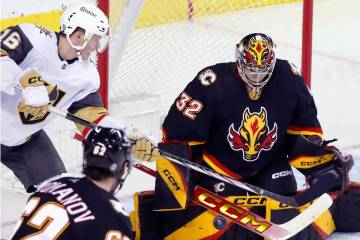 El portero de los Calgary Flames, Dustin Wolf, detiene un tiro de Pavel Dorofeyev de los Vegas ...