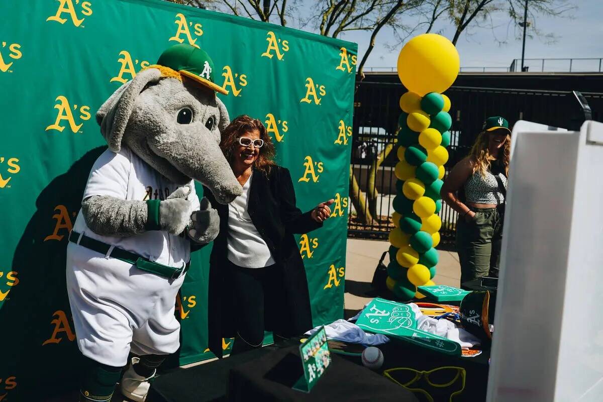 Stomper, la mascota de los Oakland A's, posa para fotografiarse con los fans durante un partido ...