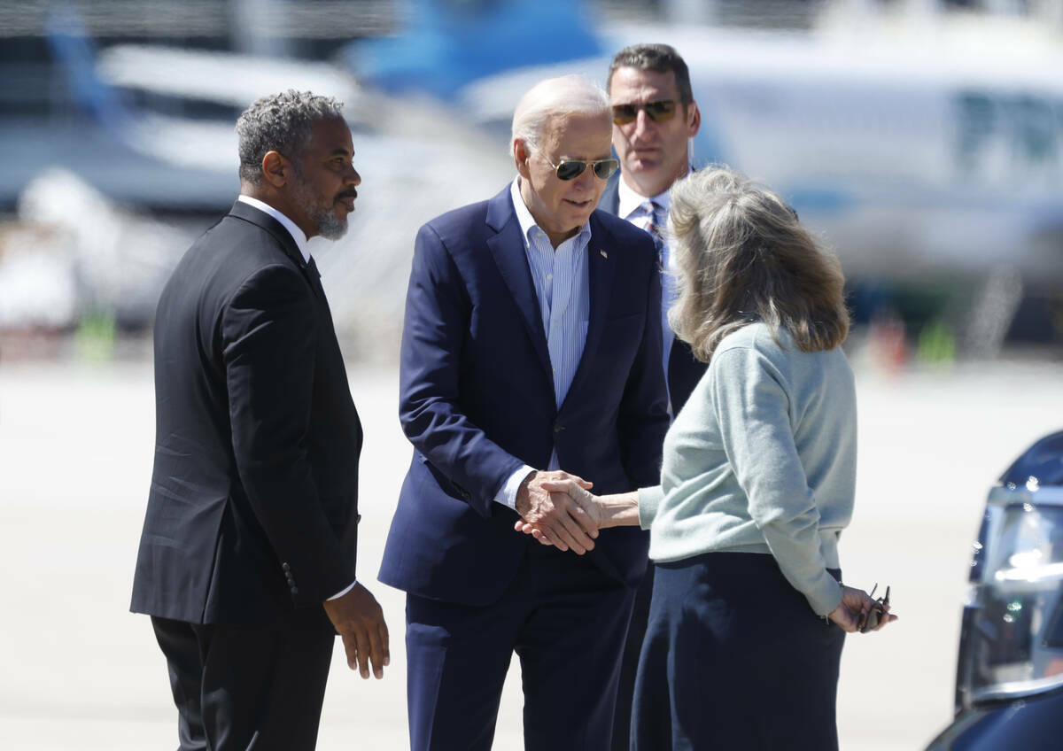 El presidente Joe Biden es recibido por el representante Steven Horsford, a la izquierda, y la ...