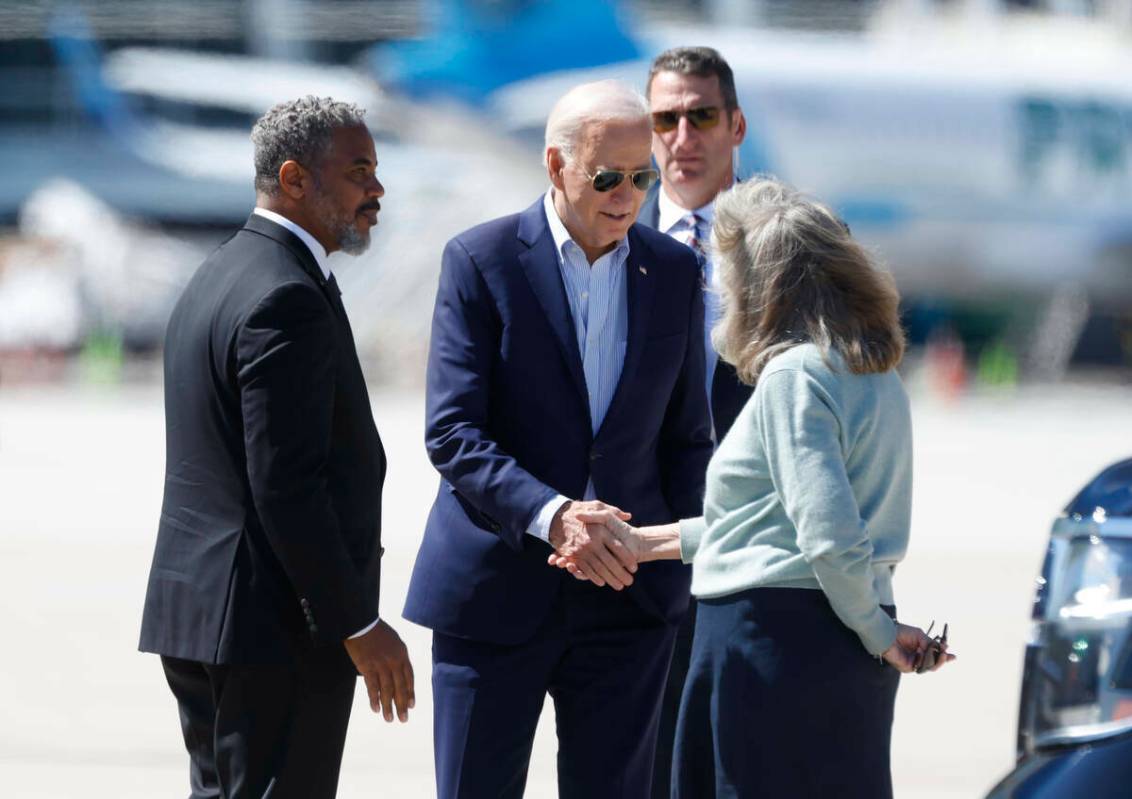 El presidente Joe Biden es recibido por el representante Steven Horsford, a la izquierda, y la ...