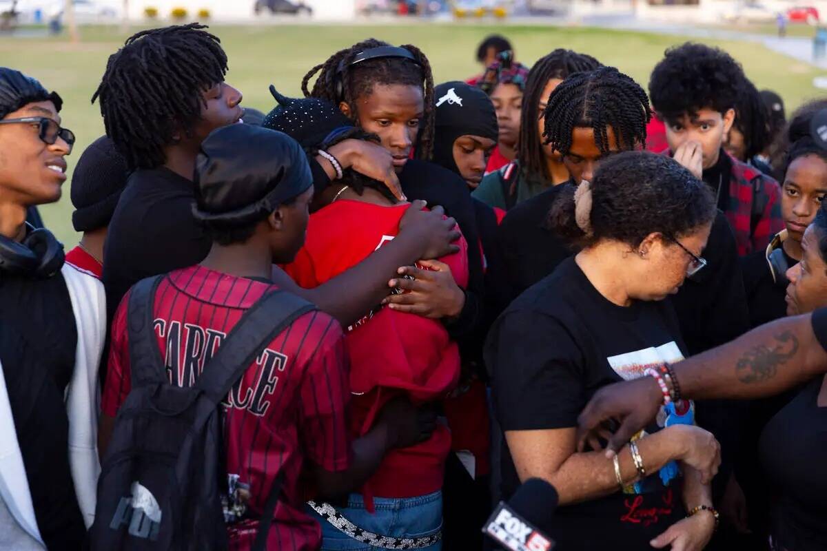 Amigos y familiares se abrazan durante una vigilia en memoria de Devin Heath, de 17 años, que ...
